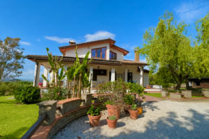 Vrijstaande Italiaanse villa met veranda, tuin en groen tijdens onze huizenzoektocht in Italië.
